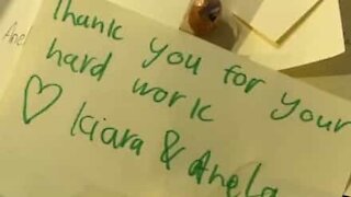Girls hand out thank you notes to supermarket workers