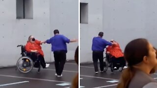 Woman in wheelchair dances with partner at concert