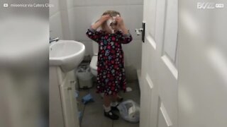 Une fillette surprise se lavant les cheveux au papier toilette