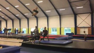 Jovem executa quadruplo salto mortal num mini trampolim
