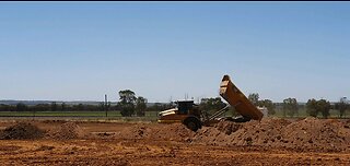 Earthworks for grain storage facility: excavator, articulated dump truck, water truck, bull dozer