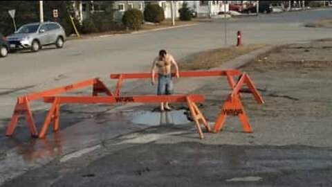 Boy jumps into "pool" in middle of road