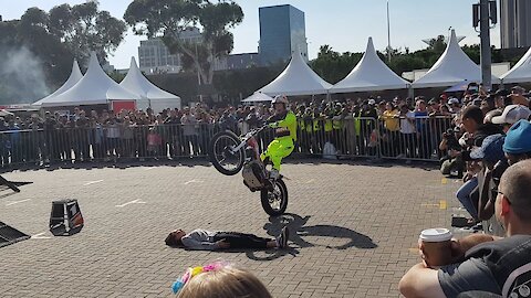 Biker performs tricks over a girl