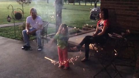 A Tot Girl Throws A Sparkler Onto Her Dad