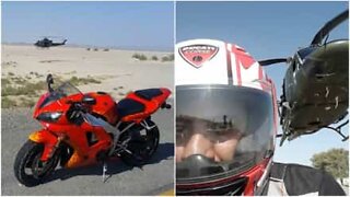 Motorcyclist speeds underneath low-flying helicopter