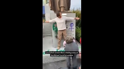 Woman protects a statue of St. Michael as feminists desecrate it in Mexico