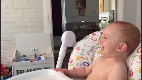 Baby can't control laughter at funny show on TV