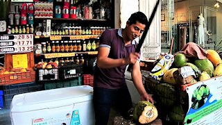 Skilled coconut vendor in Playa Del Carmen street impresses Canadian tourists