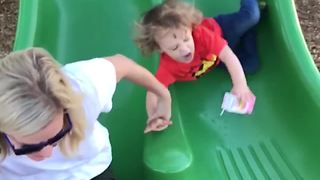 Mom Pulls Little Boy Down A Slide Onto His Face