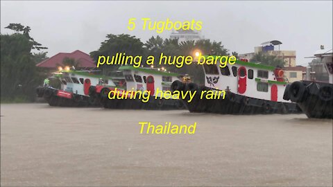 5 Tugboats pulling a huge barge during heavy rain in Thailand