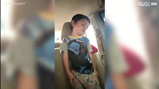 Criança dorme de pé no carro