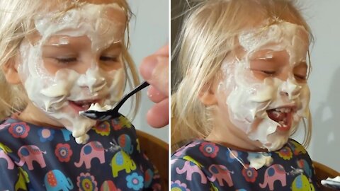 Two-year-old can't contain her laughter as dad paints her face in yogurt