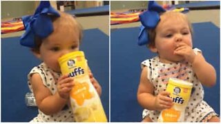 Baby doesn't need any help from parents to finish favorite snack