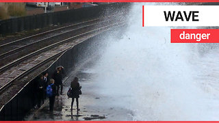 Children risking their lives by dodging huge waves on the wrong side of a seawall