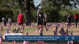 Volunteers place flags graves of fallen service members for Memorial Day