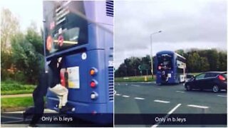 Attention, danger! Ces jeunes s'accrochent à l'arrière d'un bus.