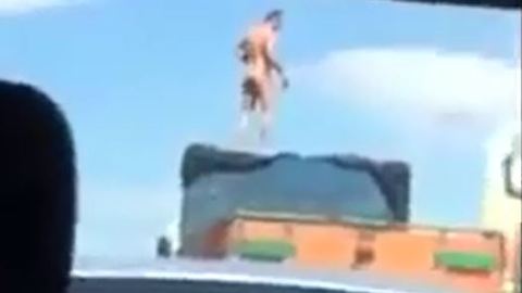 Man standing on a lorry in highway