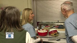 Volunteers help with serving breakfast at local shelter