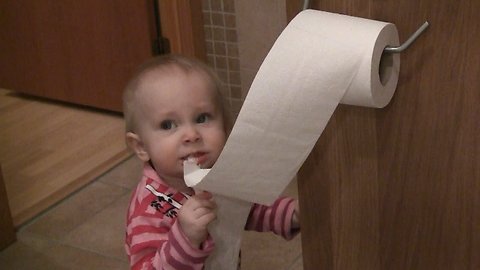 Cute baby playing with the toilet paper