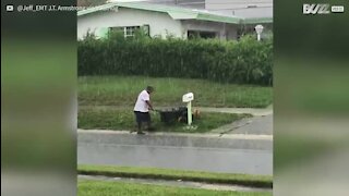 La pluie n'empêchera pas cet homme de tondre sa pelouse