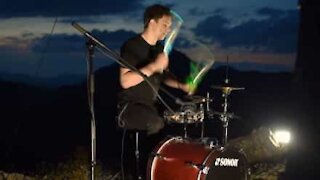 Young drummer beats out a rhythm on mountain top