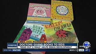 Doctors giving books to kids