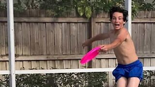 Dreng kaster frisbee i mors ansigt