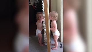 "Twin Toddler Girls Pretending To Be Each Other's Mirror Image"