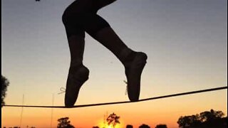 Kvinna utövar slackline med tådansteknik i balettskor