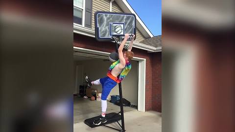 A Young Boy Takes Down A Basketball Hoop When He Slam Dunks