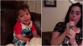 Sjov baby kan ikke lade være med at grine når mor spiller på fløjte