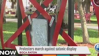 Protesters march against satanic display