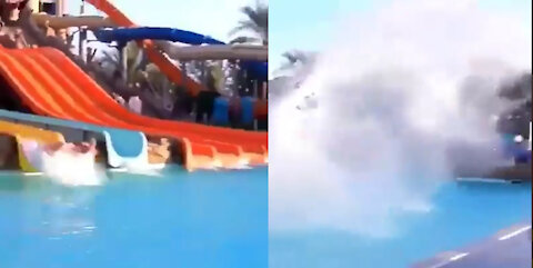 A man slides from the top and throws water out of the pool