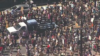 Denver police hand out water bottles to marchers Sunday