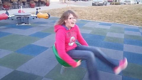 Young Girl Gets Dizzy After Spinning On A Kids’ Playground