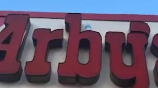 Impossible 'bottle flip challenge' on restaurant entrance sign