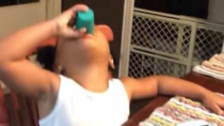 Criança tenta beber shot de suco de maçã
