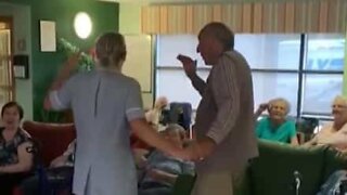 Caregiver dances the twist with nursing home resident
