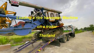 Loading a rice harvester machine in Thailand