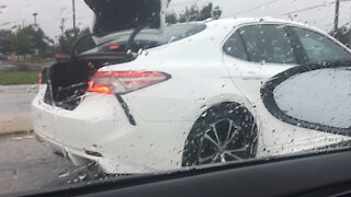 Clueless driver drives with trunk open in the rain