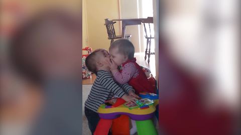 "A Tot Girl Grabs A Tot Boy and Tries to Kiss Him"
