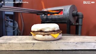 Guy adds layer of molten glass to sandwich