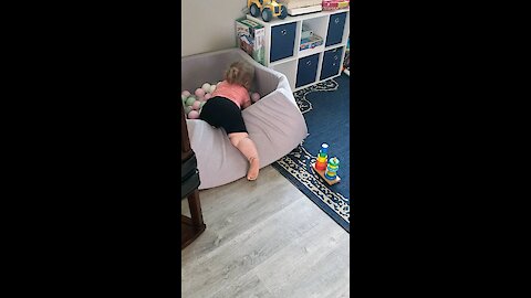 Baby girl playing in ball pit