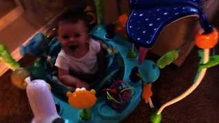Baby can't stop laughing at dog playing tug-of-war