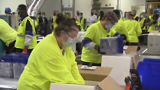 Workers at Pfizer packaging vaccine for shipment