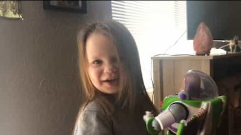 Une fillette ravie avec son jouet Buzz l'Éclair!