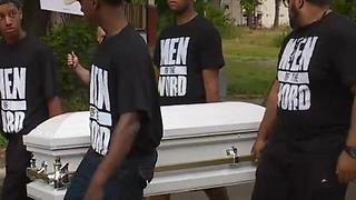 Men carrying caskets march through the streets of East Cleveland