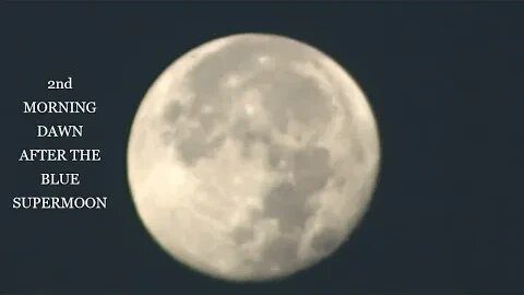 BLUE SUPERMOON NEXT MORNING SETTING OVER ROCKY MOUNTAINS OF COLORADO AT SUNRISE