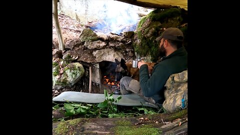Winter camping in the wild, survival shelter camp in heavy rain