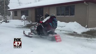 Pharmacists deliver prescriptions on a snowmobile